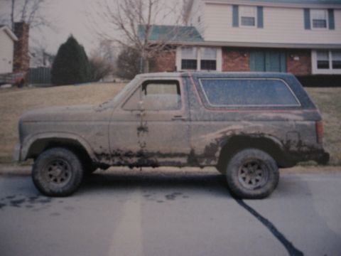 1977 Ford F-150 - This weathered Ford Bronco is parked in front of a suburban house, showing its side profile.