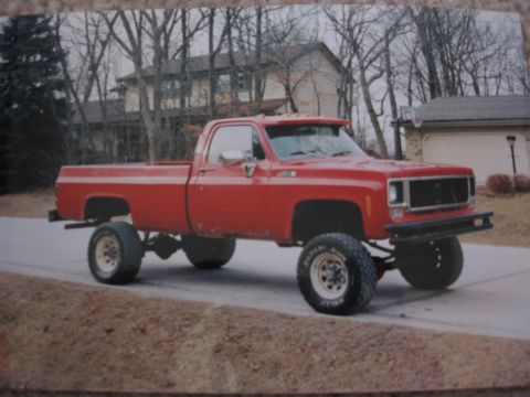 1977 Ford F-150 - This lifted red pickup truck features prominent off-road tires and a sturdy front bumper, suggesting it's built for more than just pavement.
