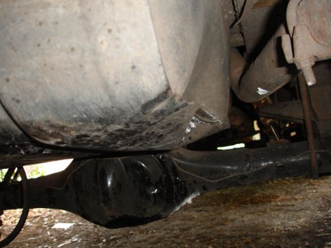 1989 Ford Bronco - The underside of a vehicle is shown, with a focus on the differential and fuel tank.