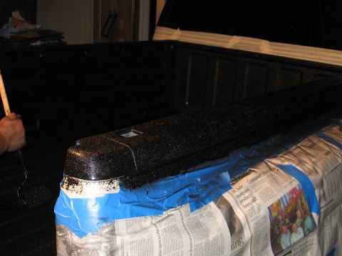 1995 GMC Sierra 1500 - Applying a protective coating to the tailgate cap of a truck bed.