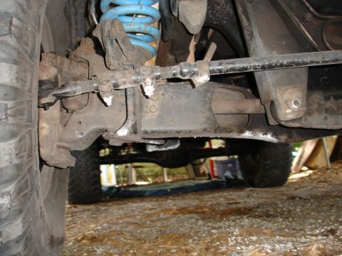 1989 Ford Bronco - Close-up view of the front suspension and steering components on a 1989 Ford Bronco, with a blue coil spring visible.
