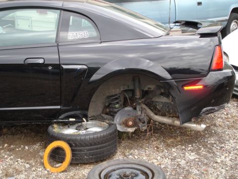 2001 Mercury Grand Marquis - This black Ford Mustang has its rear wheel removed, exposing the suspension and brake system. The number 7158 is visible on the quarter win…