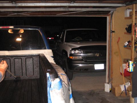 1995 GMC Sierra 1500 - A Chevrolet Silverado pickup truck is parked in a garage, with another vehicle's bed in the foreground.