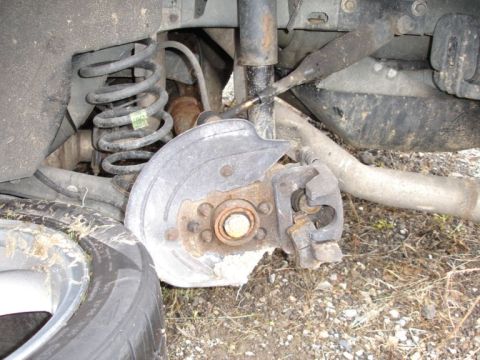 2001 Mercury Grand Marquis - Close-up view of a damaged rear wheel assembly, showing a broken brake caliper and rotor.