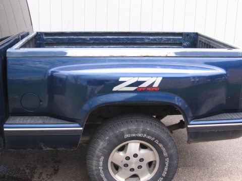 1995 GMC Sierra 1500 - The rear quarter panel of a blue pickup truck displays a Z71 Off Road decal.