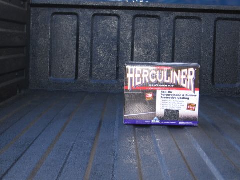 1995 GMC Sierra 1500 - Herculiner bed liner kit box placed inside a truck bed with a textured surface.