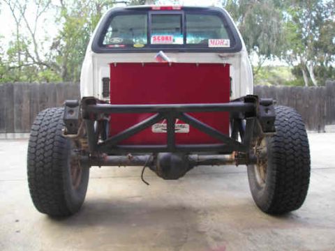 2002 Ford F-150 - This truck's rear end is exposed, showing the chassis and suspension components with a red panel installed.