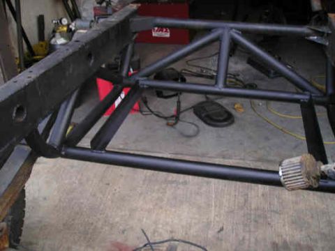 2002 Ford F-150 - A custom roll cage is welded onto a vehicle frame, likely for off-road or racing purposes.