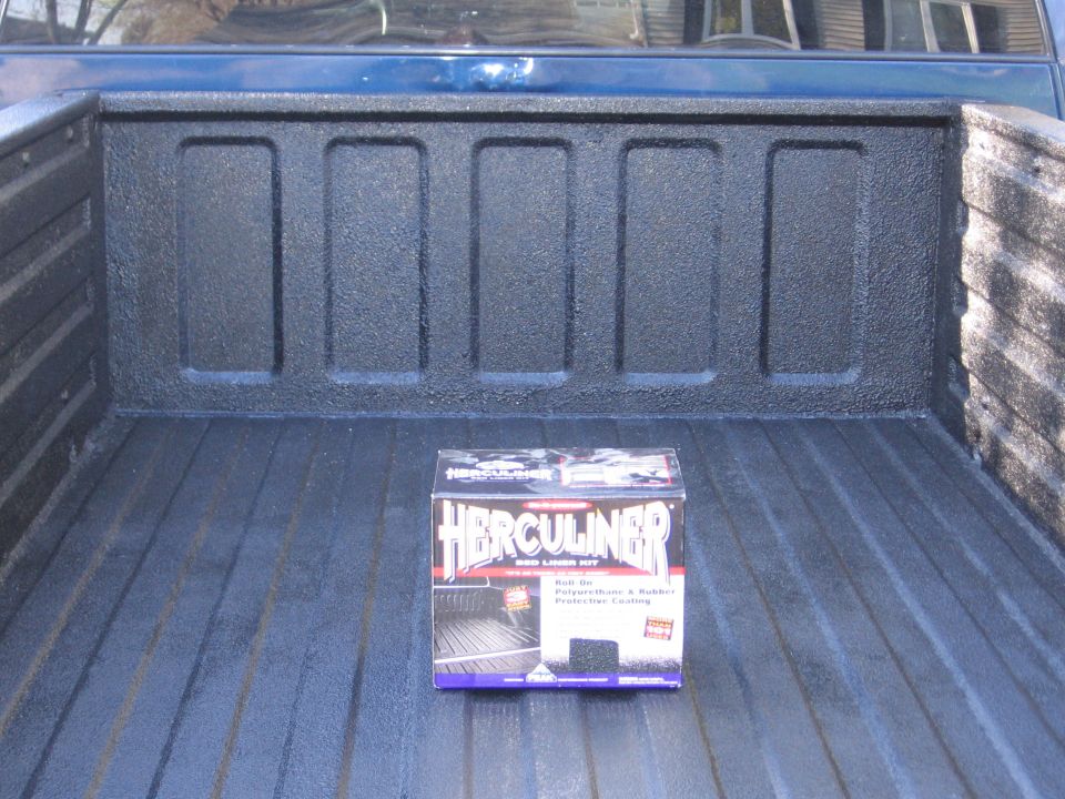 Pickup bed coated in black Herculiner bedliner with the product box sitting inside