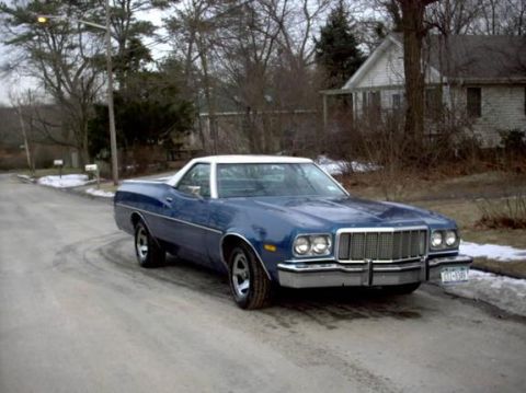 1975 Ford Ranchero - A blue 1975 Ford Ranchero with a white roof is parked on a street in front of houses.