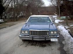 1975 Ford Ranchero - Front view of a blue sedan with a white roof, a prominent grille and a license plate.