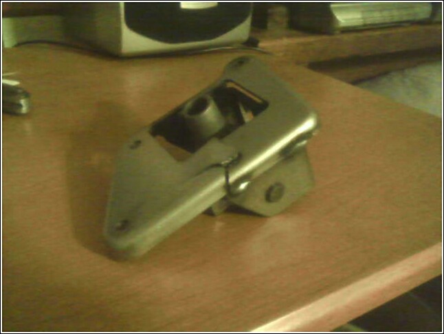 Metal bracket with pivot mechanism on a wooden surface