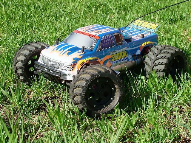 Blue and orange GS Racing Storm RC monster truck sitting in grass