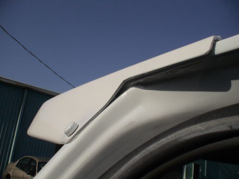 1993 Ford C-350 (Centurion Conversions) - Detail of a moonvisor mounting bracket on a vehicle's roofline.