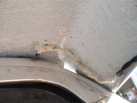 1993 Ford C-350 (Centurion Conversions) - Interior view of vehicle roof insulation and sealant, showing some wear and tear.