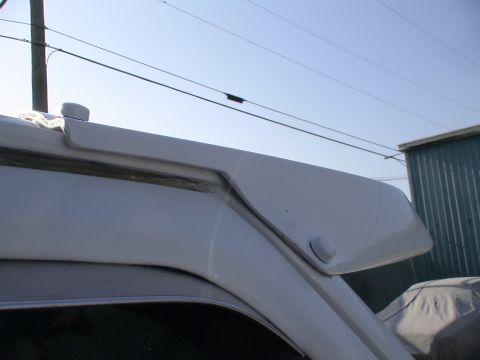 1993 Ford C-350 (Centurion Conversions) - Close-up of a vehicle's moonvisor, with a clear sky and building in the background.