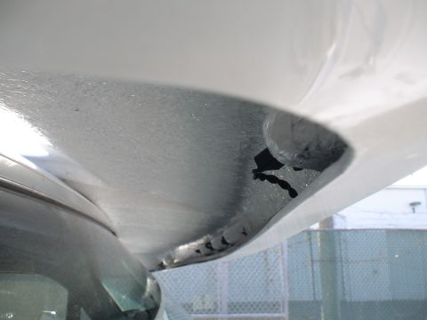 1993 Ford C-350 (Centurion Conversions) - Close-up view of the underside of a vehicle component, showing rivets and an opening.