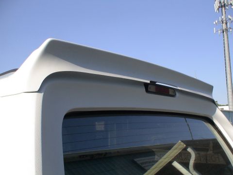 1993 Ford C-350 (Centurion Conversions) - A white rear spoiler is attached to the top of a vehicle's rear window.