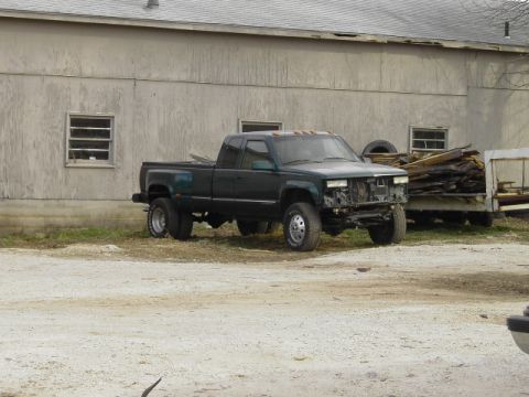 1995 GMC C/K Pickup - This 1995 GMC C/K Pickup dually truck is parked outside a building with its front end damaged.