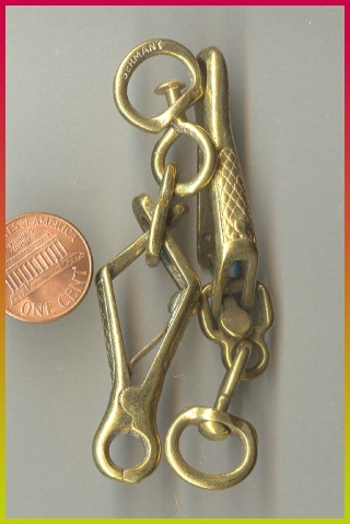 1990 Ford Bronco - A close-up view of brass hardware, including chains and clips, is shown next to a penny for scale.