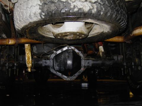 1995 GMC C/K Pickup - Underside view of a rear differential and spare tire, with visible exhaust pipes and suspension components.