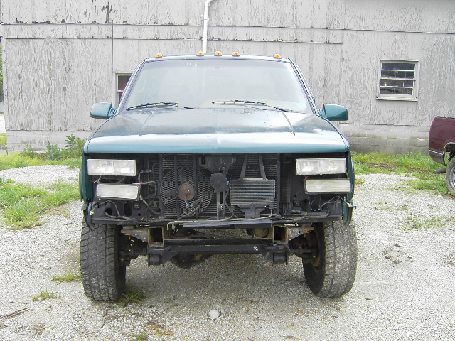 Green 1995 GMC C/K Pickup front end with missing grille and bumper