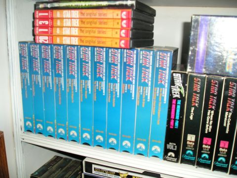 1984 Pontiac Fiero - A collection of Star Trek media, including VHS and Beta tapes, is organized on shelves.
