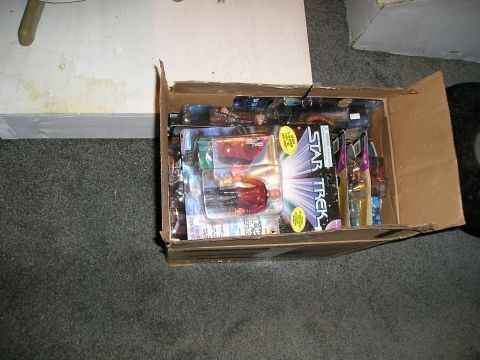 1984 Pontiac Fiero - A cardboard box overflows with various Star Trek action figures still in their original packaging.