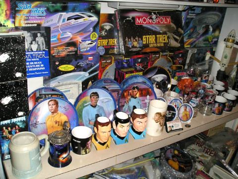 1984 Pontiac Fiero - A shelf filled with various Star Trek collectibles, including mugs, plates, and board games.
