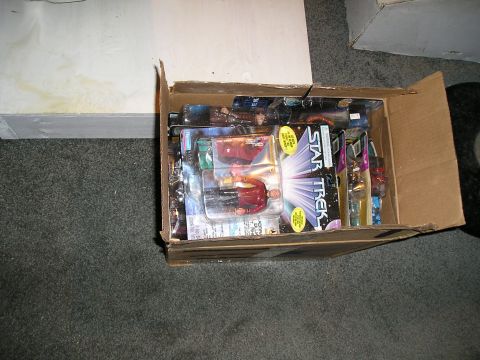1984 Pontiac Fiero - A collection of Star Trek action figures packaged for sale are visible inside a cardboard box.