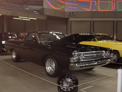 1968 Ford Ranchero - A black 1968 Ford Ranchero is displayed indoors with its hood open, alongside another vehicle.