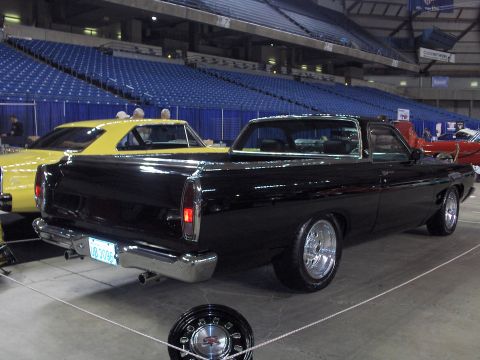 1968 Ford Ranchero - A black 1968 Ford Ranchero is parked indoors with a yellow car visible behind it.