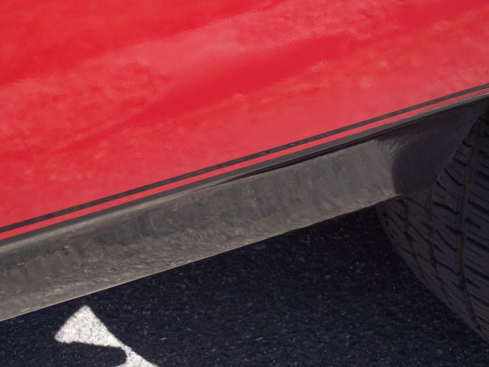 1972 Ford Ranchero side view showing red quarter panel with black stripe and tire