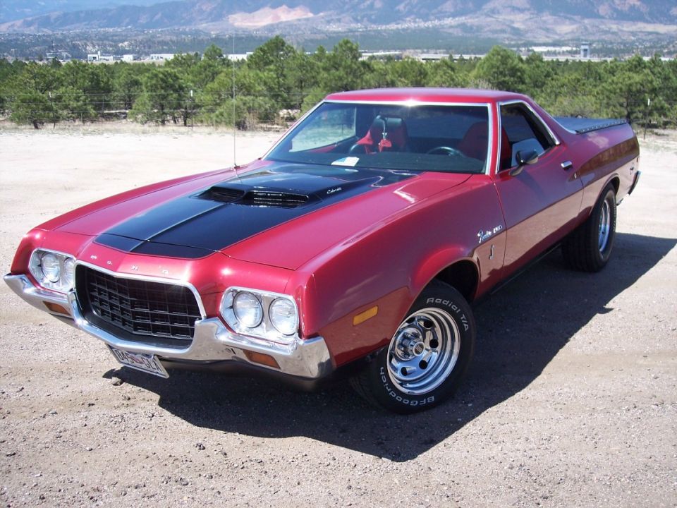 Red Ford Ranchero with black hood stripe and scoop, front three-quarter view on gravel