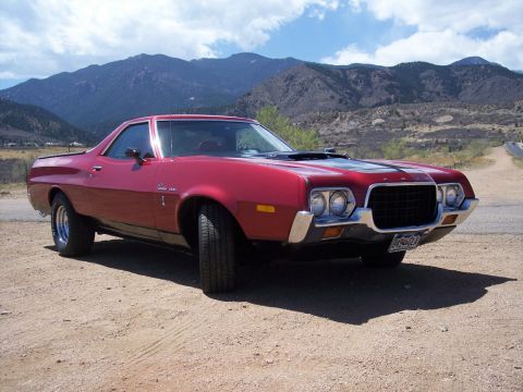 1972 Ford Ranchero - A red 1972 Ford Ranchero is parked on a dirt road with a mountainous landscape behind it.