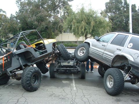 1994 Jeep YJ - Two heavily modified off-road vehicles are positioned in a precarious stack.