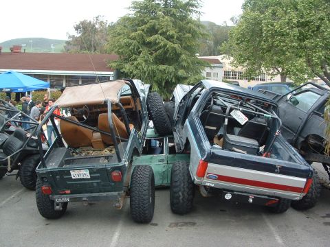 1994 Jeep YJ - Multiple off-road vehicles are crammed together, with a green Jeep YJ and a blue pickup prominently featured.