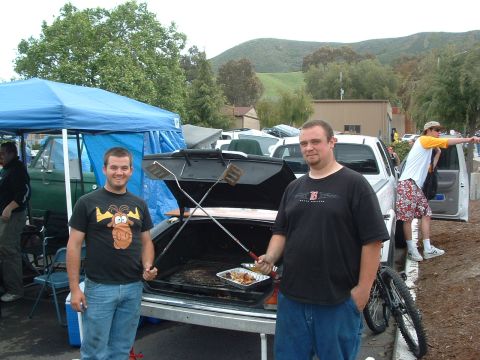 1994 Jeep YJ - Outdoor event with people and vehicles, a makeshift grill setup in a car trunk.