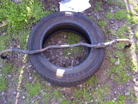 1997 Ford Taurus - A sway bar is shown resting on a TOYO PROXES tire. The registry claims it is from a 1997 Ford Taurus, but this cannot be confirmed from the…