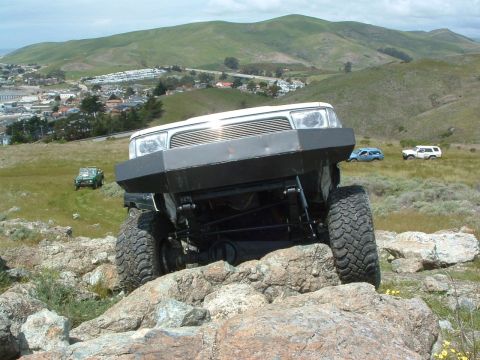 1994 Jeep YJ - This off-road vehicle, likely a 1997 model, navigates rocky terrain with a custom bumper.