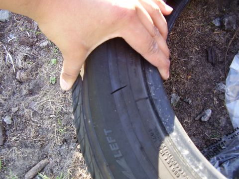 1997 Ford Taurus - Tire shows two significant cuts in the tread, indicating damage.
