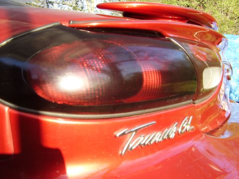1997 Ford Taurus - Close-up of a red 1997 Ford Taurus GL's rear tail light and spoiler.