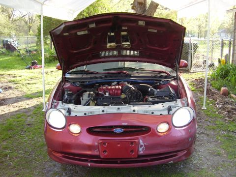 1997 Ford Taurus - Front view of a red 1997 Ford Taurus with its hood open, displaying the engine bay.