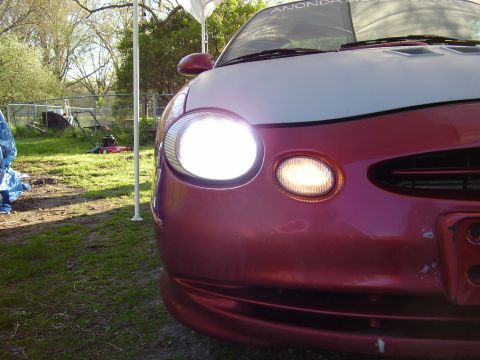 1997 Ford Taurus - Front view of a 1997 Ford Taurus with its headlights illuminated.