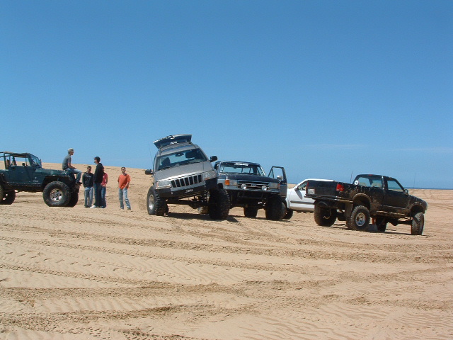 1994 Jeep YJ on sand dunes, silver, with roof rack, tilted
