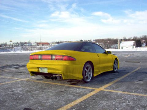 1994 Ford Probe - A yellow 1994 Ford Probe is shown from the rear in a parking lot on a clear day.