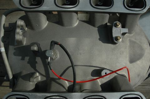 2000 Ford Mustang - Close-up of an engine intake manifold, showing a date stamp and part number.