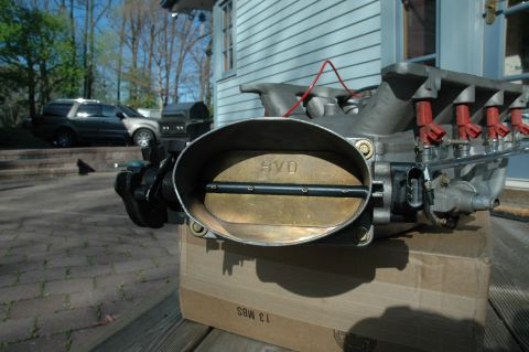 2000 Ford Mustang - Close-up of a Ford Mustang intake manifold and throttle body, labeled SVO, outdoors.