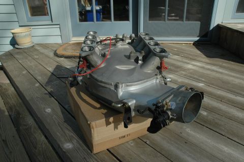 2000 Ford Mustang - An aluminum intake manifold is shown on a wooden deck, placed on top of a cardboard box.