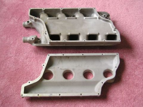 2000 Ford Mustang - Two aluminum intake manifold halves are displayed on a pink textured surface.